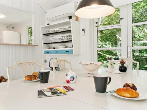 a white kitchen with a table with food on it at Holiday Home Lucie - 50m from the sea by Interhome in Rønne