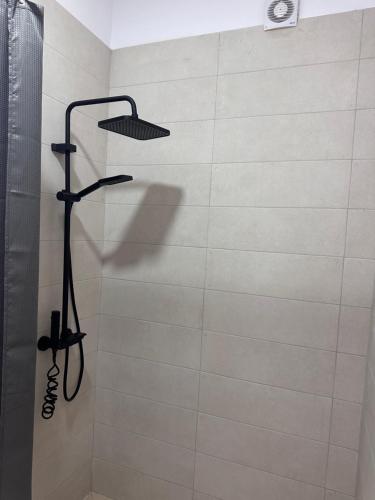 a shower in a bathroom with a shower head at Bratti's Apartment 2 Near Tirana Center And Mother Teresa International Airport in Laknas