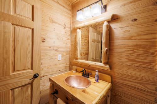 a wooden bathroom with a sink and a mirror at A Little River Romance - Private Dock - Hot Tub in Mentone