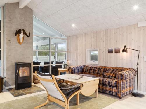 a living room with a couch and a fireplace at Holiday Home Ilsebet - 150m from the sea by Interhome in Børkop