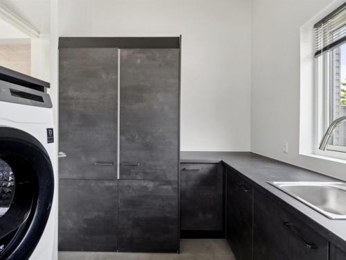 a kitchen with a sink and a washing machine at Holiday Home Nissine - 300m from the sea by Interhome in Odder