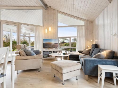a living room with a couch and a table at Holiday Home Harald - 300m from the sea by Interhome in Ørsted