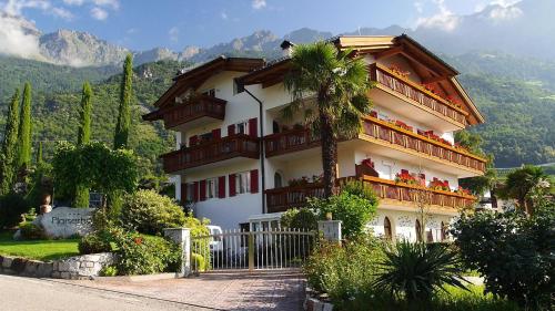 a large building with a palm tree in front of it at Plarserhof in Lagundo
