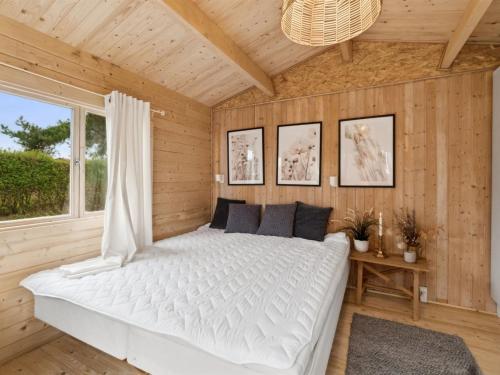 a bedroom with a white bed in a wooden room at Holiday Home Marlies - 300m from the sea by Interhome in Allinge