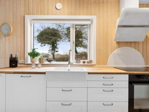 a kitchen with a sink and a window at Holiday Home Marlies - 300m from the sea by Interhome in Allinge