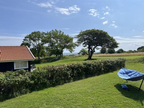 a yard with a house and a chair in the grass at Holiday Home Marlies - 300m from the sea by Interhome in Allinge