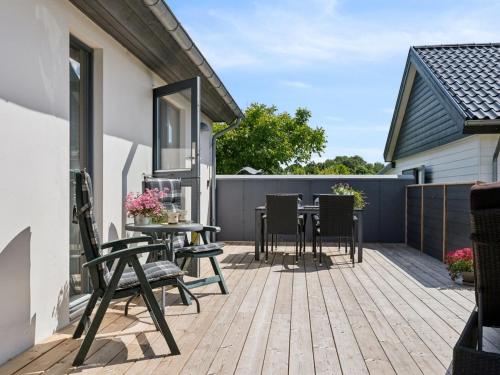 a deck with chairs and a table on a house at Holiday Home Alona - 90m from the sea by Interhome in Allingåbro
