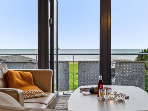 a table with a bottle of beer sitting on top of a balcony at Holiday Home Alona - 90m from the sea by Interhome in Allingåbro