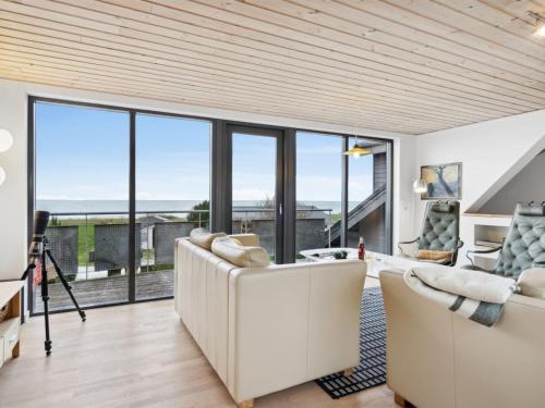 a living room with white furniture and large windows at Holiday Home Alona - 90m from the sea by Interhome in Allingåbro