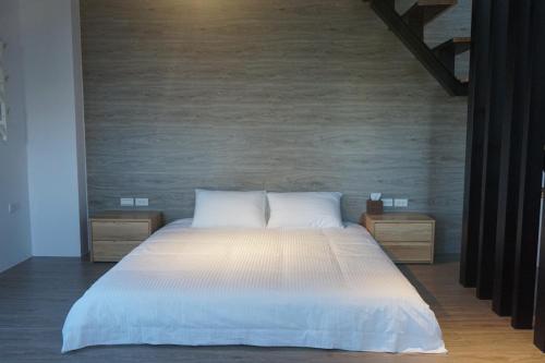 a bedroom with a white bed with two night stands at Double Egg Yolk Living Space in Dongshan