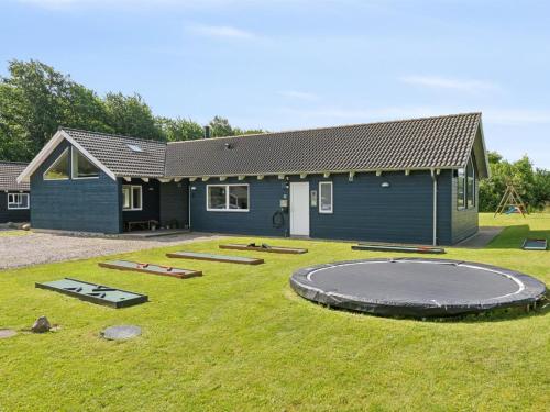 a small house with a trampoline in the yard at Holiday Home Jelke - 520m from the sea by Interhome in Tranekær