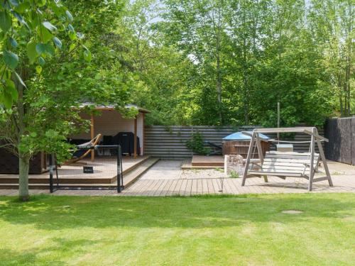 a patio with a swing and a tree at Holiday Home Kalevi - 300m to the fjord by Interhome in Grevinge