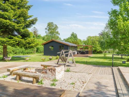 a garden with a playground and a house at Holiday Home Kalevi - 300m to the fjord by Interhome in Grevinge