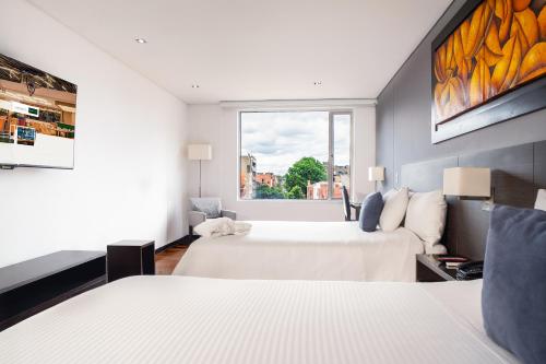 a hotel room with two beds and a window at One Sixteen Hotel in Bogotá
