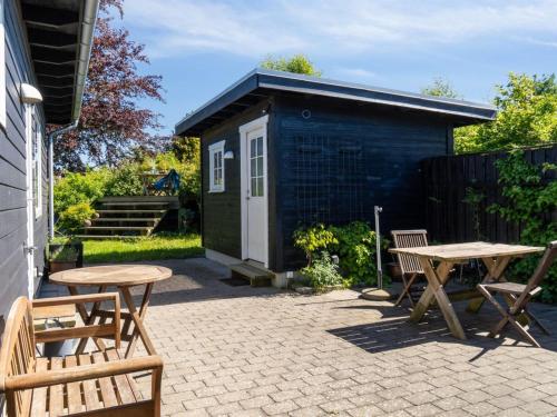 a picnic table and benches in front of a shed at Holiday Home Els - 1-8km from the sea by Interhome in Fårevejle