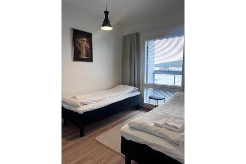 a bedroom with two beds and a window at Snowflake XI Family rooms in Rovaniemi