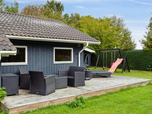 a backyard deck with a swing and a playground at Holiday Home Thorke - 200m from the sea by Interhome in Nysted