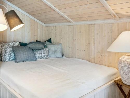a bed in the corner of a room with wooden walls at Holiday Home Thorke - 200m from the sea by Interhome in Nysted
