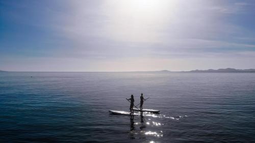 two people standing on a boat in the water at 20-30 Knots- 5br4ba Game Night Villa Hot Tub in El Sargento