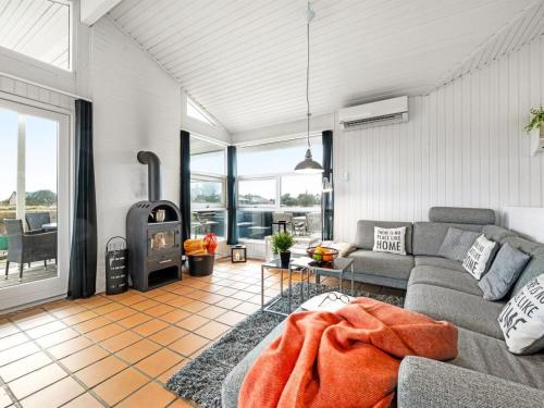 Una sala de estar con un sofá y una estufa de leña. en Holiday Home Josef - 950m from the sea by Interhome, en Fanø