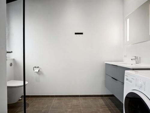 a white bathroom with a toilet and a washing machine at Holiday Home Jul - 300m from the sea by Interhome in Haderslev
