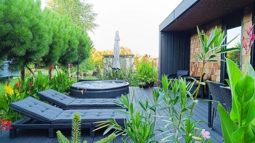 a patio with a hot tub in a garden at airzeb Uno - A3 Highway at Borș2 in Biharia