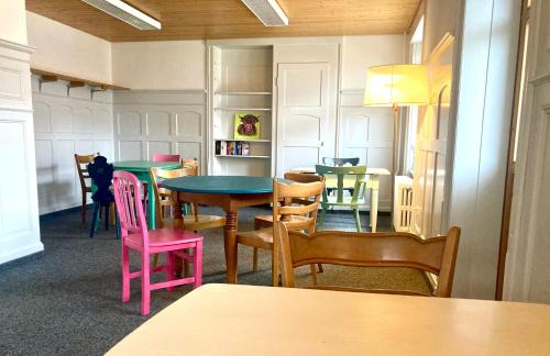 a dining room with colorful tables and chairs at Garni Sternen in Obstalden