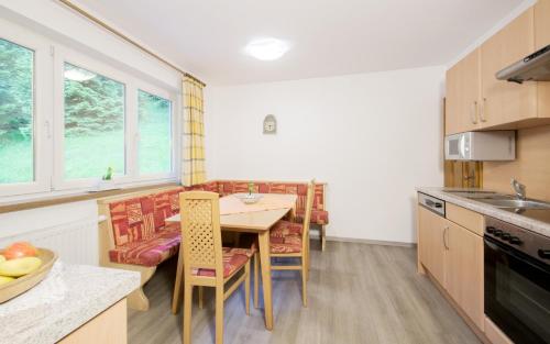 a kitchen with a table and chairs in a room at Ferienwohnung Pension Tirol in Bichlbach