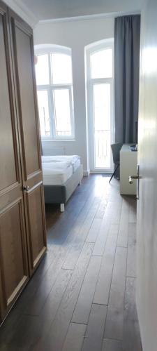a room with a bedroom with a bed and two windows at Hotel Zur Fähre in Boppard