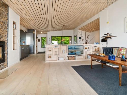 a living room with a wooden ceiling and a fireplace at Holiday Home Seetje - 200m from the sea by Interhome in Allinge