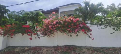a white fence with flowers hanging from it at By The Bay Oracabessa Queen Bedroom Suite in Oracabessa