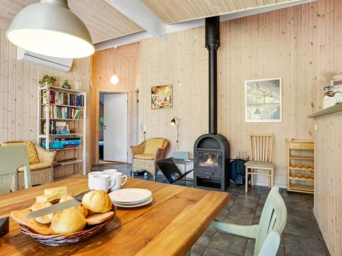 un soggiorno con un tavolo e una stufa a legna di Holiday Home Silke - 600m from the sea by Interhome a Rødby