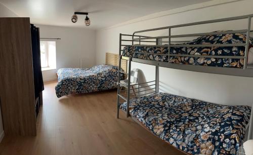 a room with two bunk beds and a bed at Hébergement La Fontaine in La Coudre