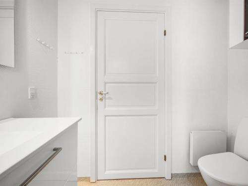 a white door in a bathroom with a toilet at Holiday Home Torhild - 700m from the sea by Interhome in Ringkøbing