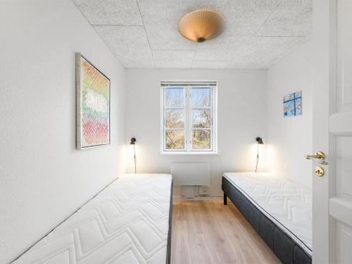 a room with two beds and a window at Holiday Home Torhild - 700m from the sea by Interhome in Ringkøbing