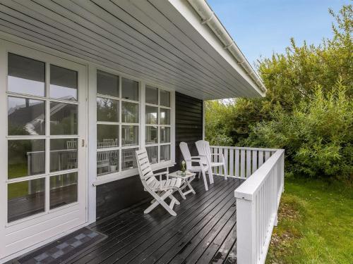 a porch with two chairs and a table on it at Holiday Home Torhild - 700m from the sea by Interhome in Ringkøbing