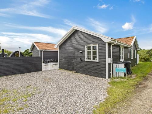 a house with a gravel driveway in front of it at Holiday Home Torhild - 700m from the sea by Interhome in Ringkøbing