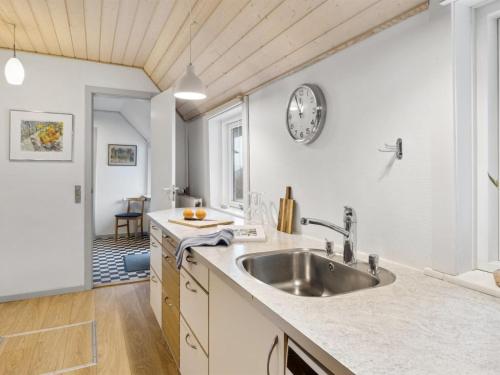 a kitchen with a sink and a clock on the wall at Holiday Home Annli - 800m to the fjord by Interhome in Fur