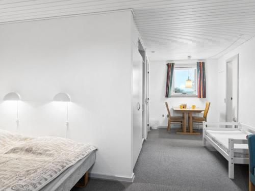 a white bedroom with a bed and a table at Holiday Home Annli - 800m to the fjord by Interhome in Fur
