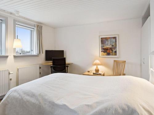 a bedroom with a large white bed and a desk at Holiday Home Annli - 800m to the fjord by Interhome in Fur