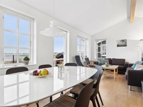 a dining room and living room with a white table and chairs at Holiday Home Ewelina - 150m from the sea by Interhome in Bagenkop