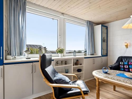 a room with a table and chairs and windows at Holiday Home Aletha - 300m to the fjord by Interhome in Snedsted