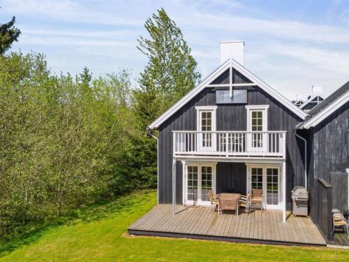 a black and white house with a deck at Holiday Home Tian by Interhome in Gjern