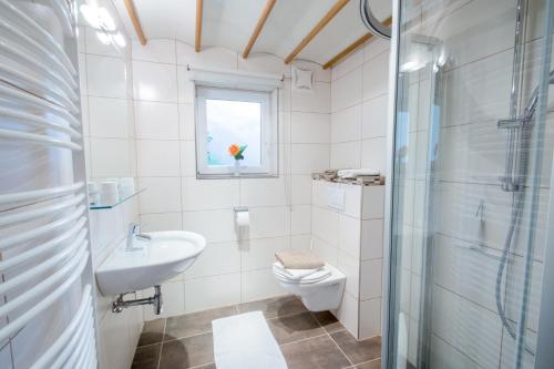 a bathroom with a sink toilet and a window at Ferienwohnung Pension Tirol in Bichlbach