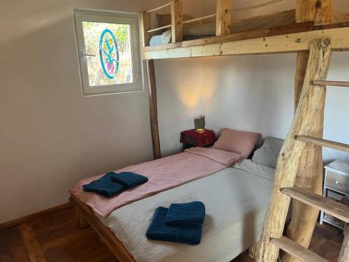 a bedroom with a bunk bed with two blue towels on it at Casinha Ninho da Mãe in Rogil