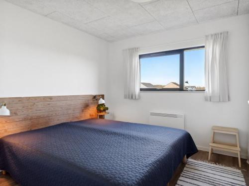 a bedroom with a blue bed and a window at Holiday Home Cresta - 1-4km from the sea by Interhome in Løkken