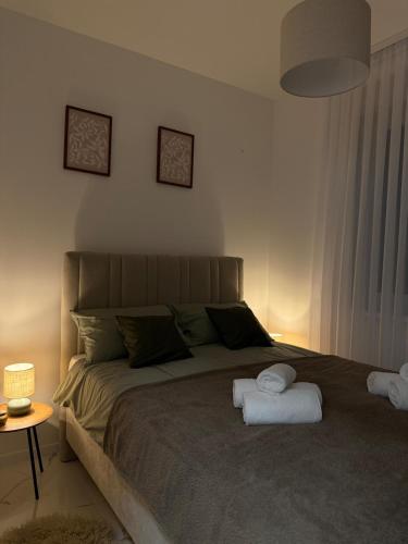 a bedroom with a bed with two towels on it at Apartman Dukat- Luksuzna novogradnja u srcu Vinkovaca s parkingom in Vinkovci