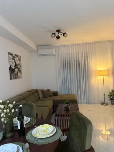 a living room with a couch and a table at Apartman Dukat- Luksuzna novogradnja u srcu Vinkovaca s parkingom in Vinkovci