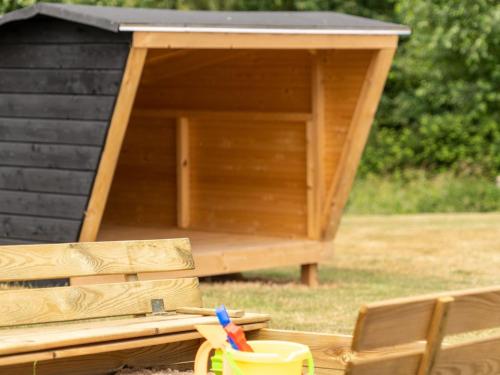 a wooden out house with a table and a pair of scissors at Holiday Home Sira - 350m from the sea by Interhome in Spodsbjerg