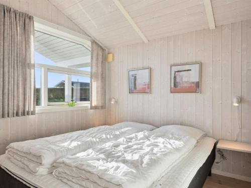 a white bed in a room with a window at Holiday Home Sira - 350m from the sea by Interhome in Spodsbjerg